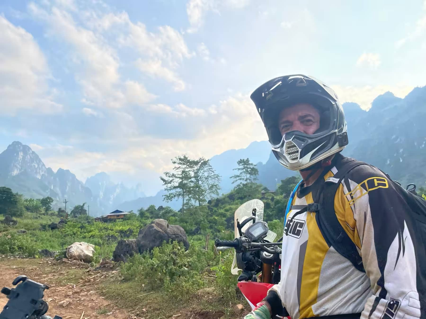 A helmeted guest rider looking back at the camera with karst peaks behind