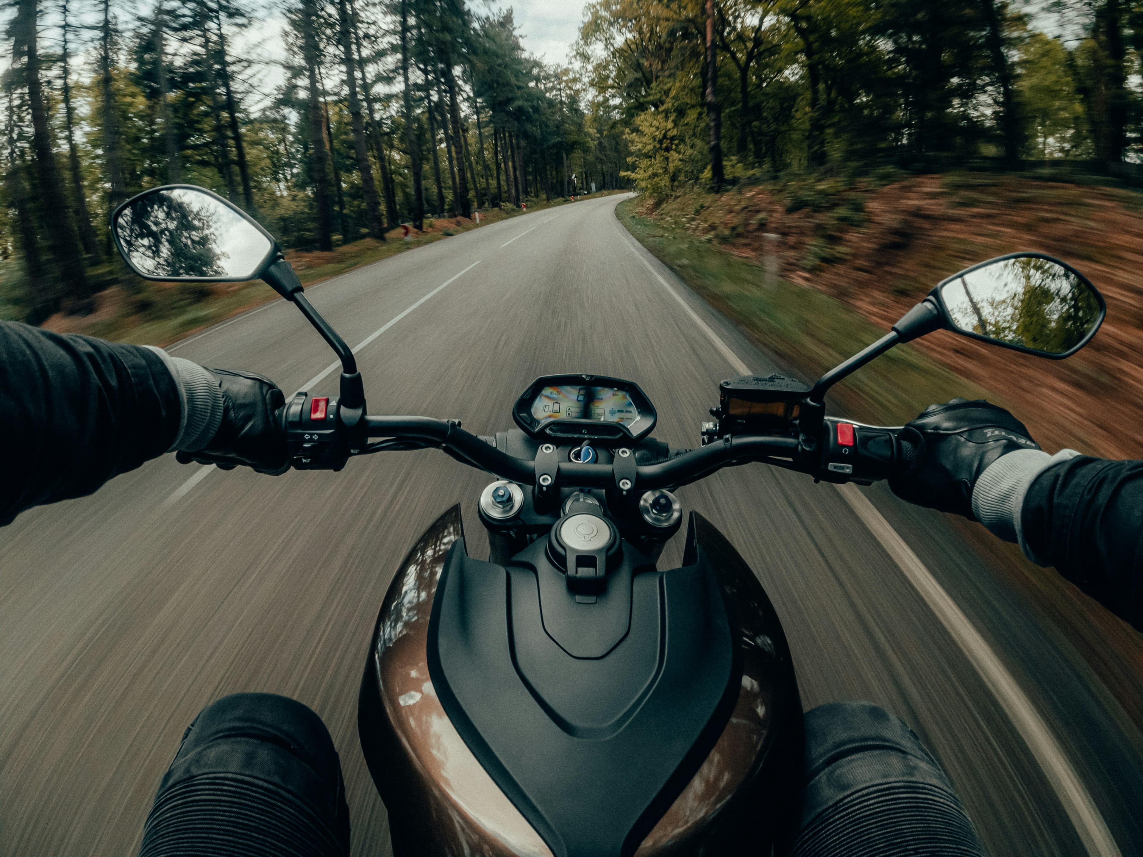 Rider's point of view over the handlebars on an open road