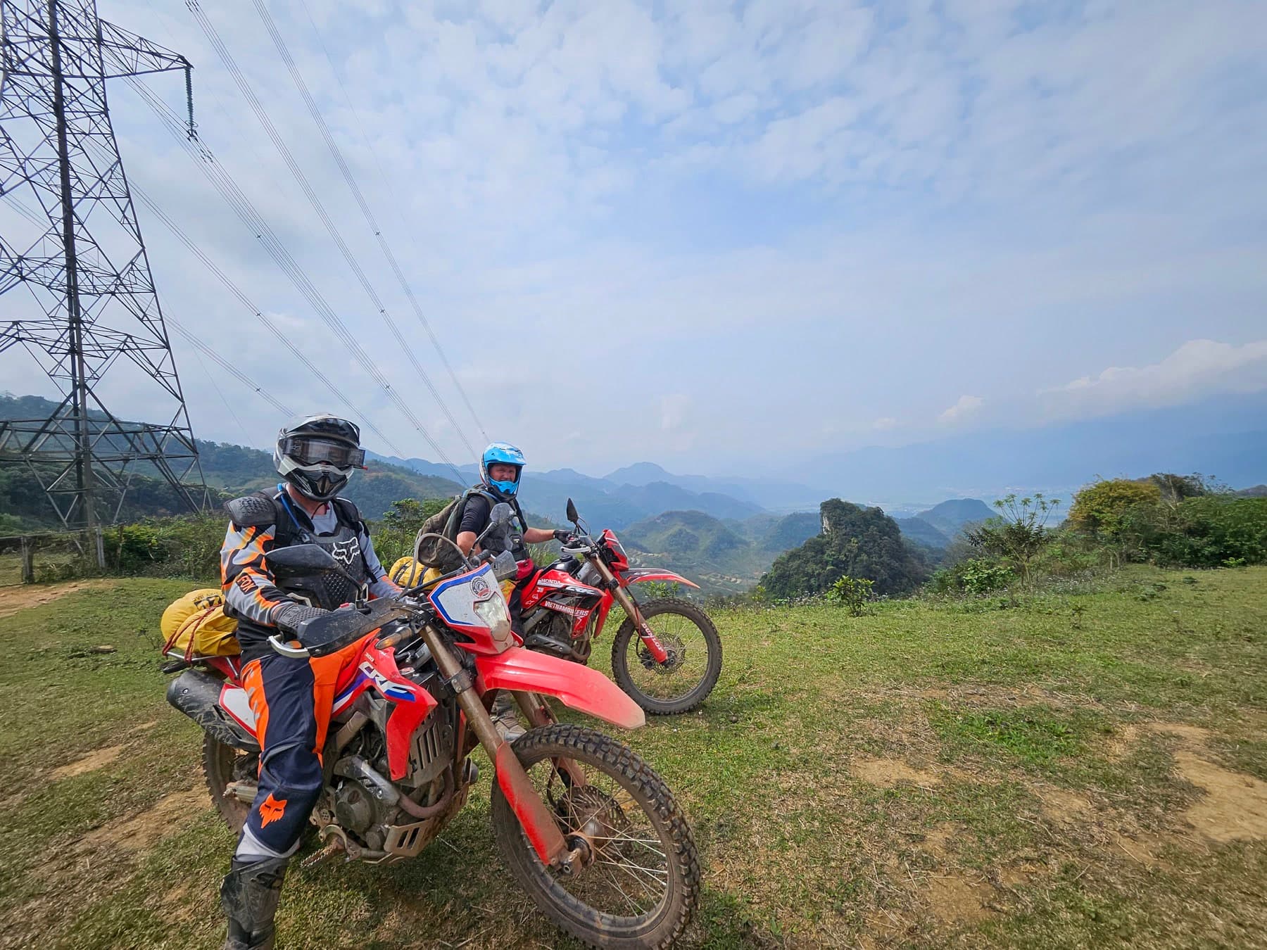 Dirt bike riders on a wide mountain ridge viewpoint