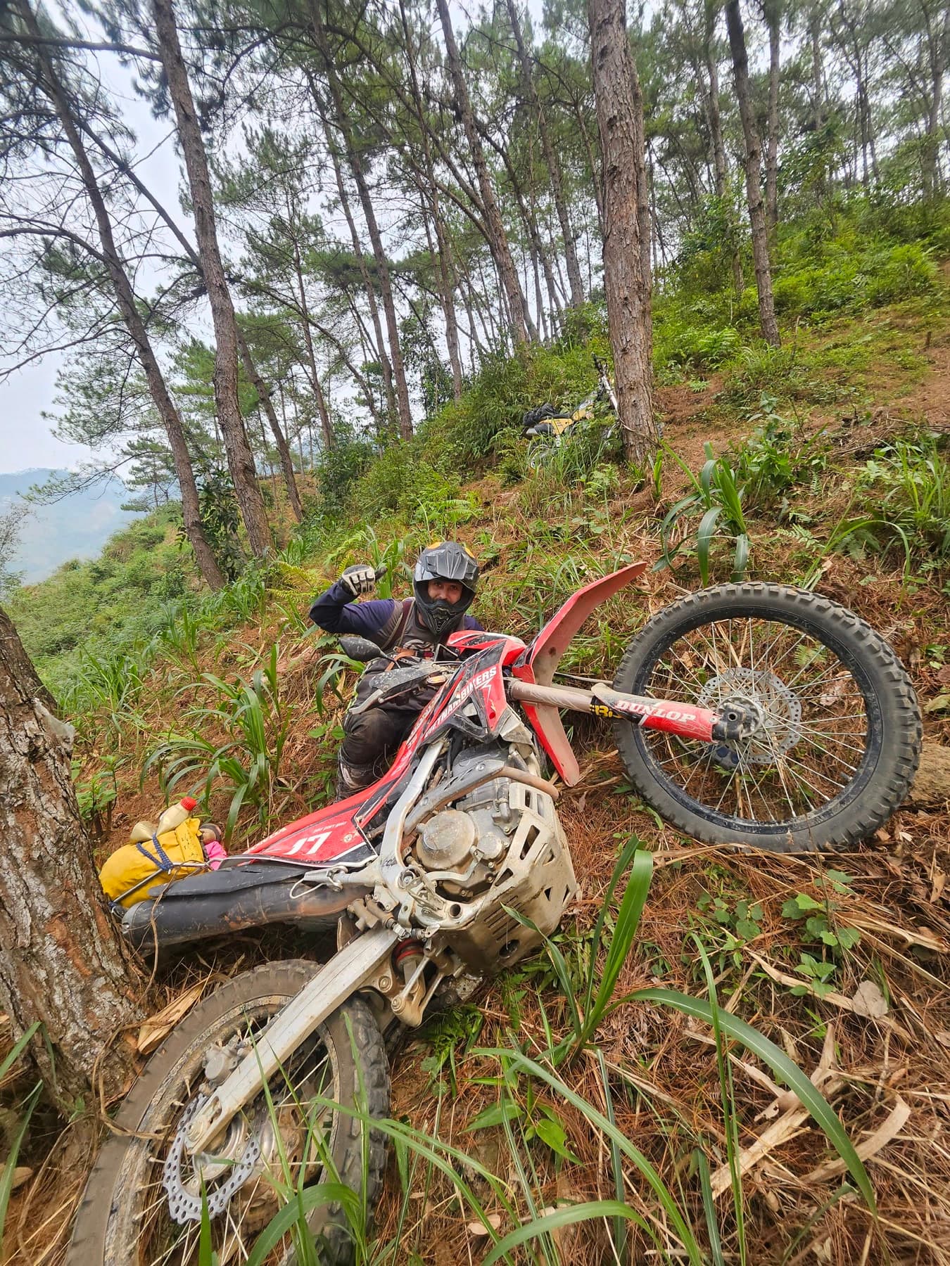 Dirt bike recovery on a steep forest trail